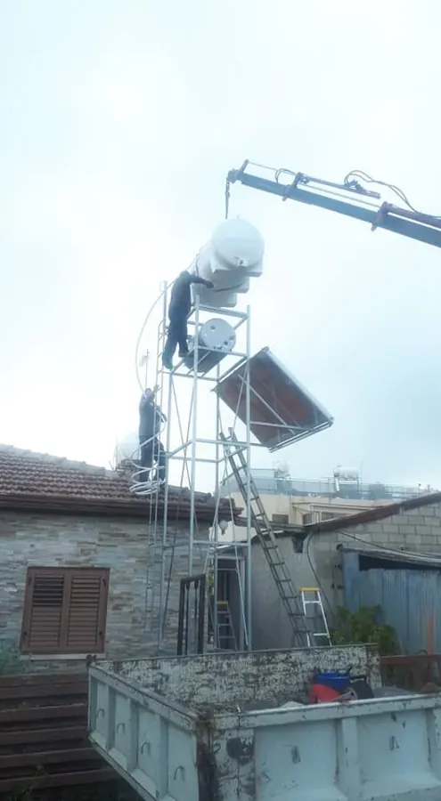 Solar water heater lifted onto a roof by crane